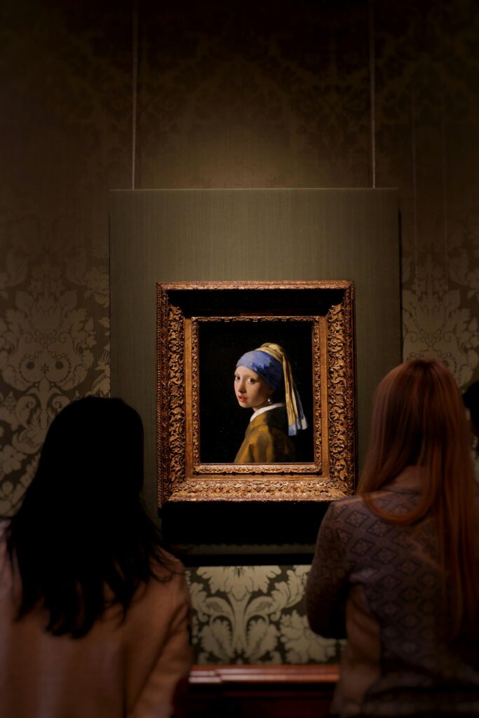 Tourists view the iconic Vermeer painting at Mauritshuis, The Hague.